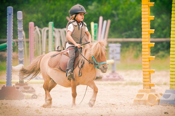 Petite fille qui fait du cheval au centre équestre de Pouzac.